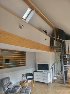 ein Wohnzimmer mit einer Treppe und einem TV in der Unterkunft Unterm Skywalk in Brehme