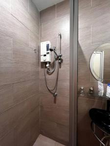 een badkamer met een douche, een wastafel en een spiegel bij SEMI D Melaka.BBQ.Pool.Dart in Melaka