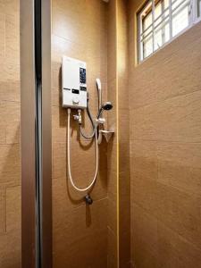 een douche in een badkamer met een zeepdispenser aan de muur bij SEMI D Melaka.BBQ.Pool.Dart in Melaka