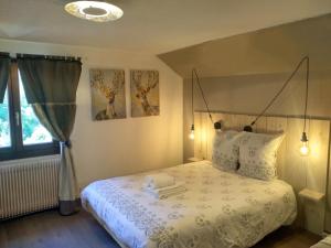 a bedroom with a bed with a white comforter at Les Sapins in Bussang