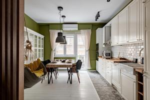 een keuken met groene muren en een tafel en stoelen bij Synagogue Central Kira Apartment in Boedapest +13 foto's