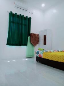 Habitación con cama y cortina verde en CozyL Homestay in 3 minutes drive to Redang Jetty, en Kampong Ru Sepuloh