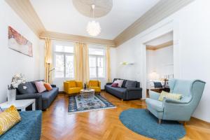 Il comprend un salon doté d'un mobilier bleu et jaune ainsi que de parquet. dans l'établissement GRAND DELUXE ViP APARTMENT, à Prague