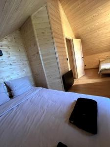 a bedroom with a white bed in a wooden room at Superbe Chalet Cabane Chabanon in Selonnet