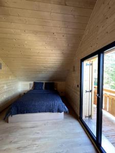Bett in einem kleinen Zimmer mit Fenster in der Unterkunft Superbe Chalet Cabane Chabanon in Selonnet