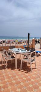 una mesa y sillas en un patio con vistas a la playa en duplex sobre la playa, en La Manga del Mar Menor
