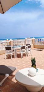 una mesa con sillas y una piña en un patio en duplex sobre la playa, en La Manga del Mar Menor