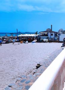 una playa de arena con sombrillas y gente en ella en duplex sobre la playa, en La Manga del Mar Menor