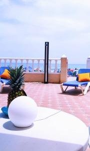 una piña sentada sobre una mesa junto a la playa en duplex sobre la playa, en La Manga del Mar Menor