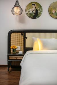a bedroom with a bed and a side table with flowers at Media Central Hotel & Spa in Hanoi