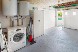 a laundry room with a washing machine in it at La Cabane des Bords de Loire in Saint-Sébastien-sur-Loire