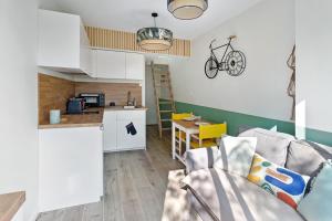 a living room with a couch and a kitchen at Loft des bords de Loire, idéal voyage d'affaires & Week end in Saint-Sébastien-sur-Loire