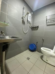 e bagno con doccia, servizi igienici e lavandino. di Ayana Homestay a Labuan
