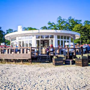 un grupo de personas sentadas en un restaurante en la playa en Friesland Glamping Camp Schortens, en Schortens