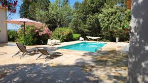 basen z 2 krzesłami i parasolem w obiekcie La Bastide Blanche Magnifique villa 5 étoiles 5 chambres et piscine privée sur 6500 m VAR w mieście Lorgues