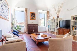 uma sala de estar com um sofá e uma mesa em Livorno-Mercato delle Vettovaglie Central Apt! em Livorno