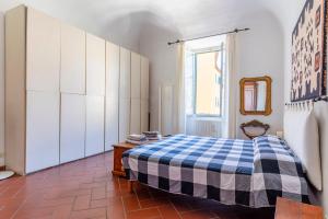 um quarto com uma cama azul e branca e uma janela em Livorno-Mercato delle Vettovaglie Central Apt! em Livorno