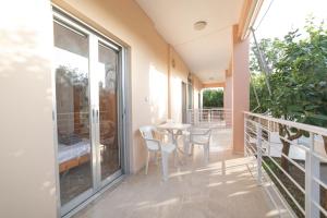 un balcón de una casa con mesa y sillas en Olive Apartments Elaionas, en Eleonas
