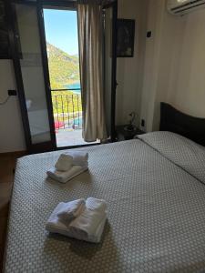 una camera da letto con due asciugamani su un letto con finestra di B&B La Bastia a Scilla