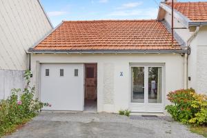 ein weißes Haus mit einer Garage und einem roten Dach in der Unterkunft L'Escale du Voyage à Nantes in Saint-Sébastien-sur-Loire