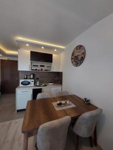 uma cozinha e sala de jantar com uma mesa de madeira e cadeiras em Golden view apartment - Milmari p82 FREE SPA APRIL, MAY AND JUNE!!!! em Kopaonik
