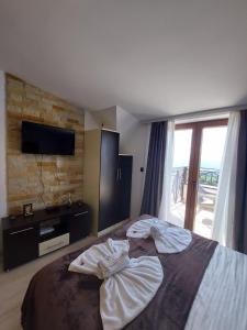 um quarto com uma cama grande e uma televisão na parede em Golden view apartment - Milmari p82 FREE SPA APRIL, MAY AND JUNE!!!! em Kopaonik