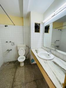 a bathroom with a toilet and a sink at Gautam Hotel in Varanasi