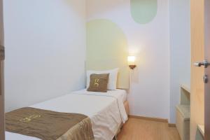 Postel nebo postele na pokoji v ubytování Hotel Gunawangsa Manyar