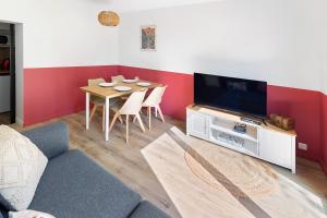 ein Wohnzimmer mit Tisch und Fernseher in der Unterkunft L'Escale du Voyage à Nantes in Saint-Sébastien-sur-Loire