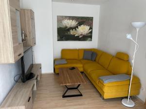 uma sala de estar com um sofá amarelo e uma mesa em FEWO CELINE em Wasserhofen