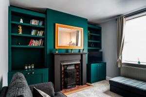 a living room with green walls and a fireplace at Steeple View House in Lincolnshire
