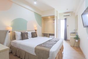 a bedroom with a large bed and a television at Hotel Gunawangsa Manyar in Surabaya