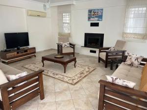 een woonkamer met banken en een flatscreen-tv bij Villa Melissa Fethiye in Fethiye
