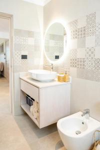 W białej łazience znajduje się umywalka i lustro. w obiekcie Aqua Esmeralda Luxury Beach Front Apartment w mieście La Laguna