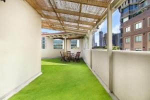 a balcony with green grass and a table and chairs at VENUS Harbourside - FEMALE ONLY HOSTEL in Sydney