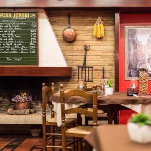 un restaurante con una mesa y un menú en la pared en Classic Can Jeroni, en Figueres