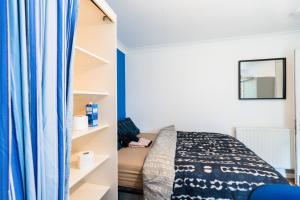 a bedroom with a bed and a blue curtain at Charming 6-Bed House in Reading in Reading