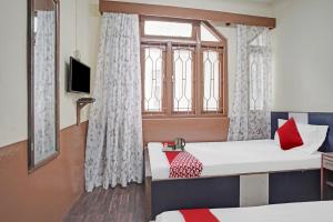 a room with two beds and a window at OYO 88696 Hotel Siddarth in Gangtok