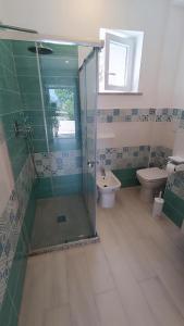 a bathroom with a glass shower and a toilet at Passariello in Ischia