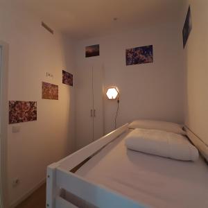 um quarto com uma cama com uma luz na parede em Ático Rural en pareja, amigos o familia a la montaña "EL COLMENAR" em Chóvar