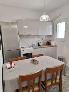 a kitchen with a table with chairs and a refrigerator at Sea La Vie in Korinthos