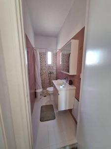 een kleine badkamer met een wastafel en een toilet bij Sea La Vie in Korinthos
