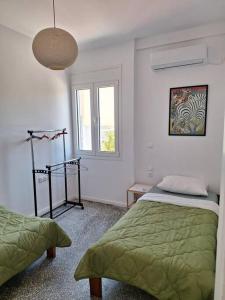 um quarto com 2 camas e uma janela em Sea La Vie em Corinto