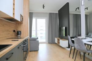 a kitchen and living room with a table and chairs at Komfortowy Apartament w Warszawie, Bemowo, Lazurowa, blisko Metra in Warsaw