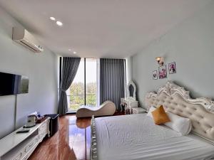 a bedroom with a large white bed and a large window at Royal Homestay in Tuy Hoa