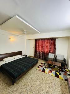 a bedroom with a bed and a couch and a table at Gautam Hotel in Varanasi