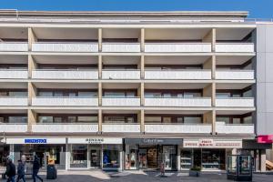 an apartment building with white balconies and people walking in front at Haus Christianenhoehe Whg 10 in Westerland (Sylt)