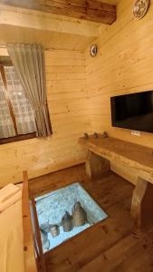 a room with a tub in a wooden room with a tv at Casa de Lemn Maramures in Mara