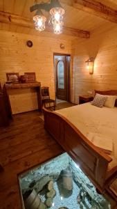 a bedroom with a bed and a fish tank in the floor at Casa de Lemn Maramures in Mara