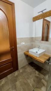 a bathroom with a white sink and a mirror at Casa de Lemn Maramures in Mara +71 photos